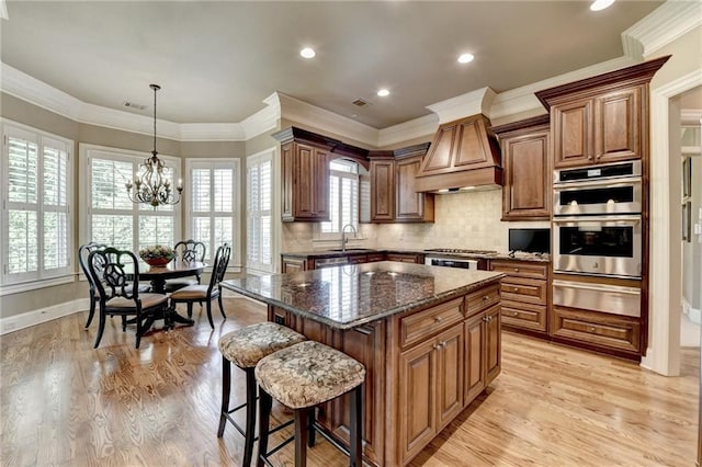 8340 Royal Melbourne Way, Duluth, GA 30097 - kitchen featuring a warming drawer, stainless steel double oven, premium range hood, a center island, and dark stone counters