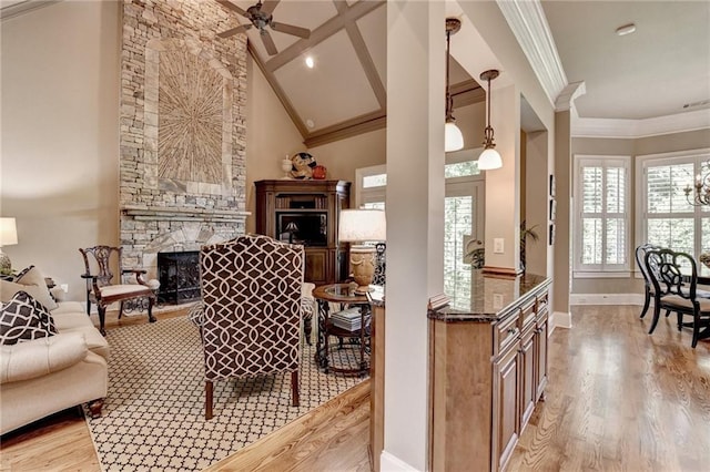 8340 Royal Melbourne Way, Duluth, GA 30097 - living area with a stone fireplace, light wood finished floors, ornamental molding, baseboards, and ceiling fan