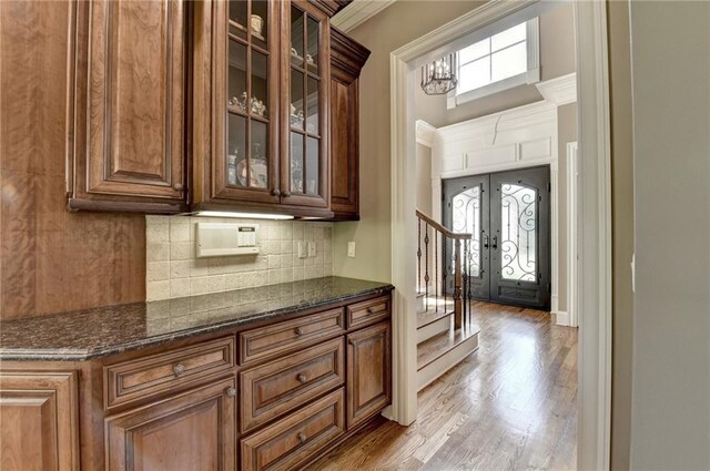 8340 Royal Melbourne Way, Duluth, GA 30097 - bar featuring backsplash, light wood finished floors, stairs, and ornamental molding