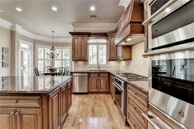 8340 Royal Melbourne Way, Duluth, GA 30097 - kitchen with appliances with stainless steel finishes, a sink, crown molding, custom range hood, and dark stone countertops