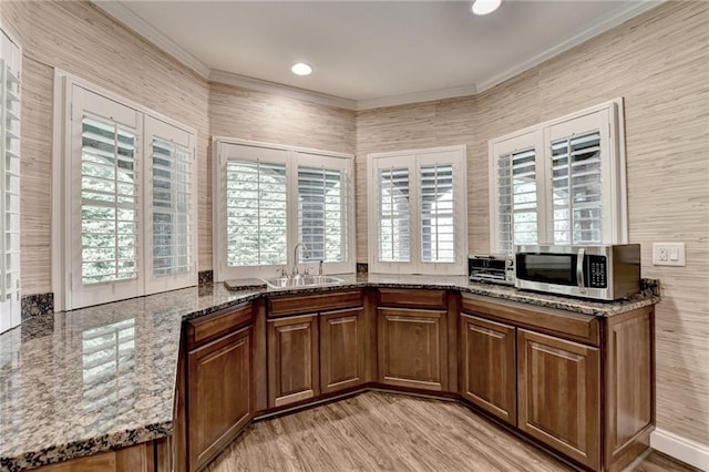8340 Royal Melbourne Way, Duluth, GA 30097 - kitchen with stainless steel microwave, a sink, crown molding, healthy amount of natural light, and stone counters