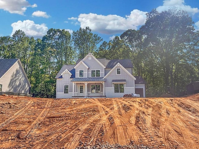 back of property featuring a porch, board and batten siding, metal roof, and a standing seam roof