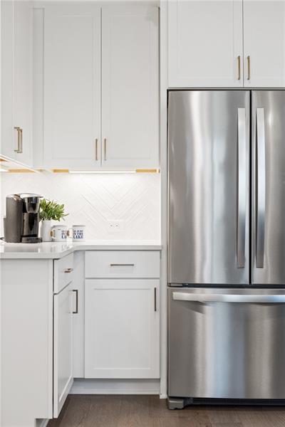 9110 Greenway Ct, Gainesville, GA 30506 - kitchen with freestanding refrigerator, light countertops, white cabinetry, and tasteful backsplash