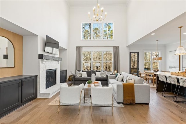 9110 Greenway Ct, Gainesville, GA 30506 - living room featuring a chandelier, a towering ceiling, light wood-style floors, plenty of natural light, and crown molding