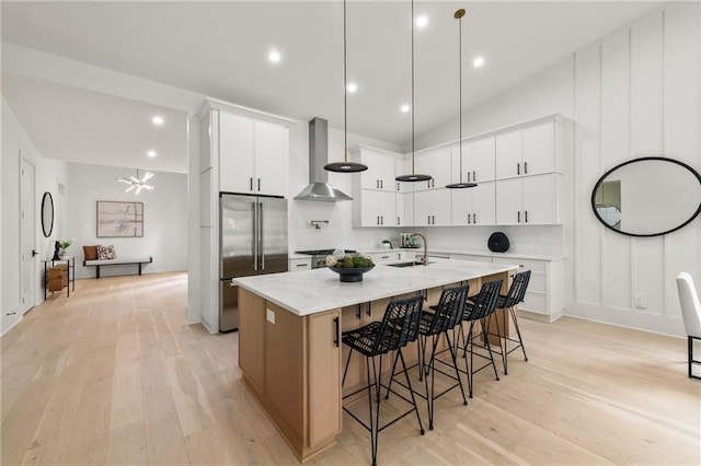 6178 Lake Lanier Height Rd, Buford, GA 30518 - kitchen featuring wall chimney range hood, high end fridge, light wood finished floors, a spacious island, and a breakfast bar