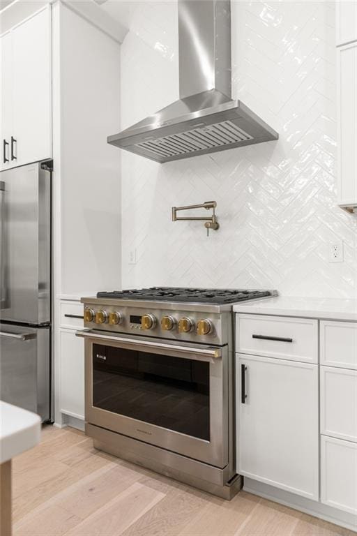 6178 Lake Lanier Height Rd, Buford, GA 30518 - kitchen with appliances with stainless steel finishes, wall chimney exhaust hood, white cabinetry, light countertops, and tasteful backsplash