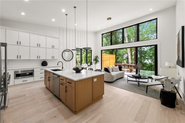 6178 Lake Lanier Height Rd, Buford, GA 30518 - kitchen with stainless steel appliances, a towering ceiling, light wood finished floors, light countertops, and recessed lighting