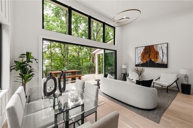 6178 Lake Lanier Height Rd, Buford, GA 30518 - living room featuring healthy amount of natural light, a chandelier, a high ceiling, and wood finished floors