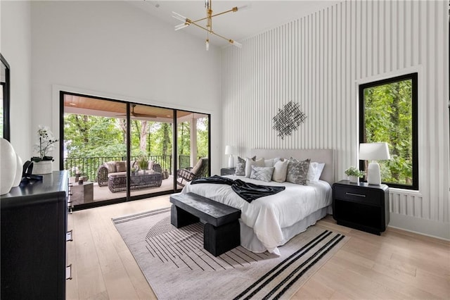 6178 Lake Lanier Height Rd, Buford, GA 30518 - bedroom featuring a towering ceiling, access to exterior, light wood-style floors, and a chandelier