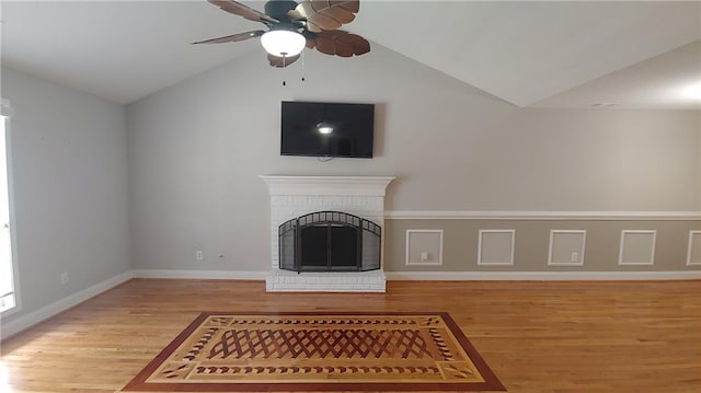 unfurnished living room featuring a fireplace, hardwood / wood-style flooring, ceiling fan, and lofted ceiling