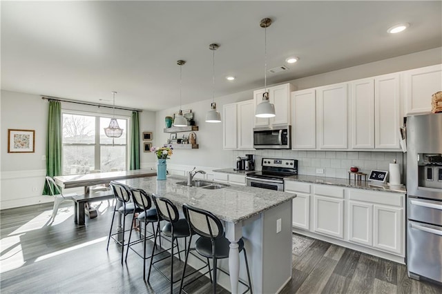 kitchen featuring appliances with stainless steel finishes, a sink, white cabinets, and recessed lighting