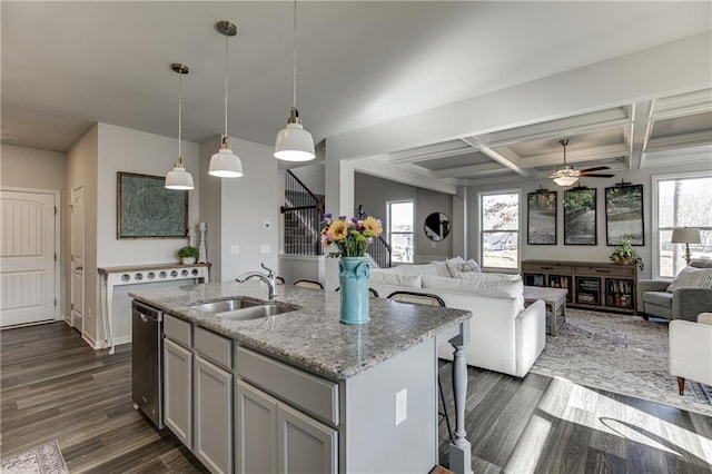 kitchen featuring a sink, open floor plan, a ceiling fan, a center island with sink, and dishwasher