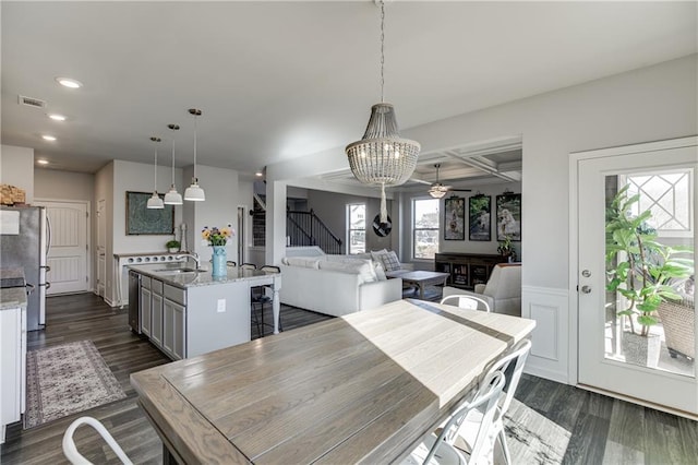dining space with dark wood-style flooring, recessed lighting, a chandelier, and stairs