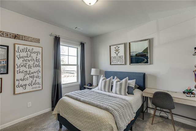 carpeted bedroom with baseboards and a desk