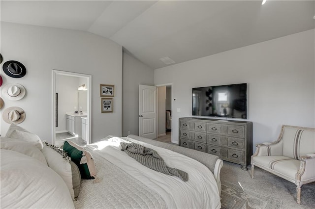 carpeted bedroom featuring lofted ceiling, connected bathroom, and baseboards