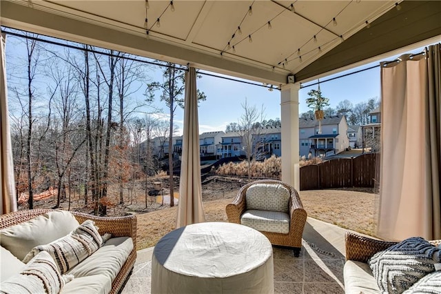 view of patio featuring an outdoor living space, a residential view, and fence