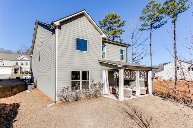 rear view of house with a patio area and cooling unit