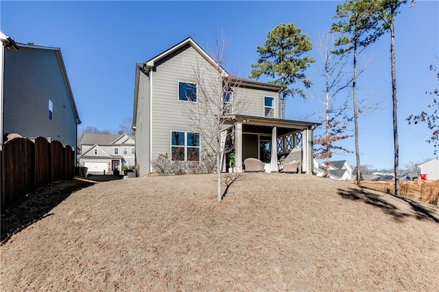 rear view of house featuring fence