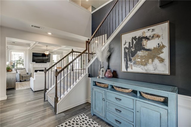 stairway with ceiling fan, a fireplace, wood finished floors, and recessed lighting