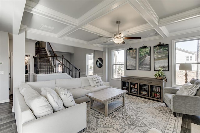 living area featuring stairs, a ceiling fan, coffered ceiling, wood finished floors, and crown molding