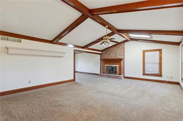 unfurnished living room with carpet, a brick fireplace, ceiling fan, and lofted ceiling with skylight