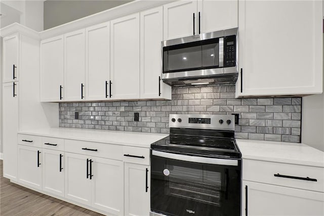 kitchen featuring white cabinets, light hardwood / wood-style flooring, electric range, and decorative backsplash