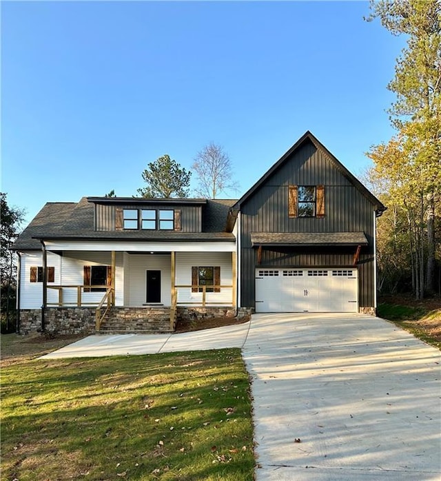 view of front facade featuring a porch, a garage, and a front yard