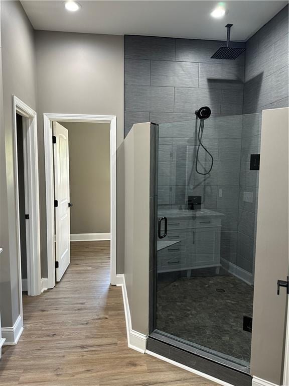 bathroom with an enclosed shower and hardwood / wood-style floors