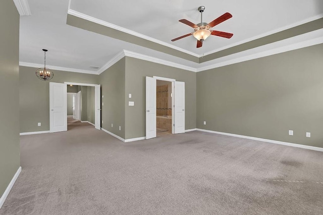 empty room with ceiling fan with notable chandelier, ornamental molding, carpet, and a tray ceiling