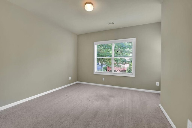 unfurnished room featuring light carpet