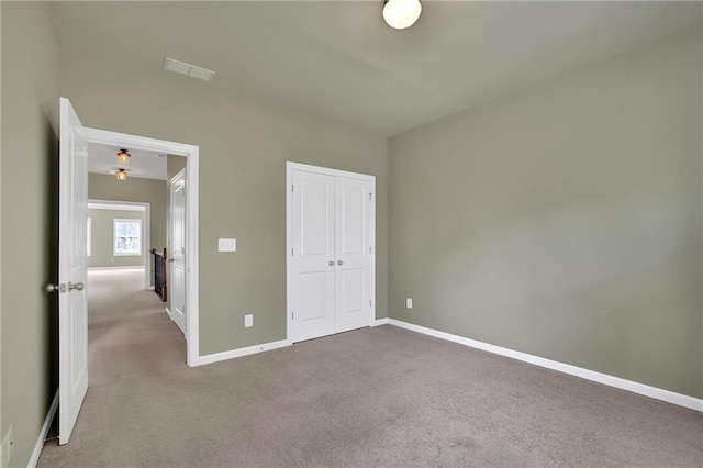 unfurnished bedroom with a closet and carpet flooring