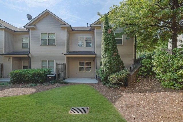 back of property with a lawn, a patio, and central AC