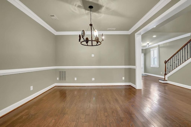 spare room featuring an inviting chandelier, crown molding, and dark hardwood / wood-style flooring