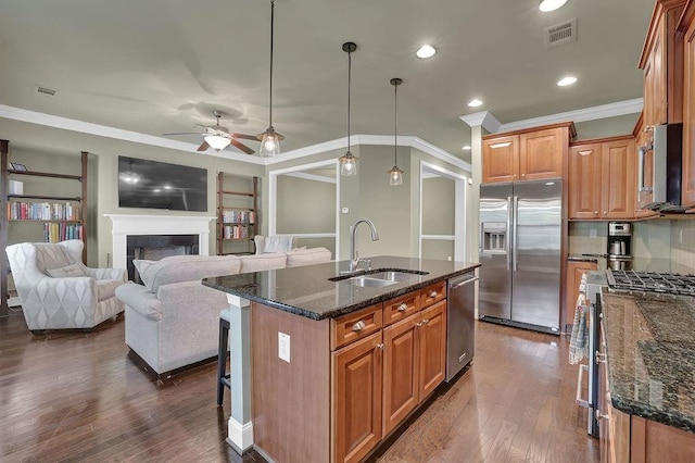 kitchen featuring an island with sink, pendant lighting, stainless steel appliances, ceiling fan, and sink