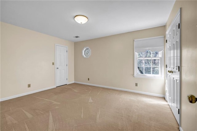 carpeted spare room featuring visible vents and baseboards