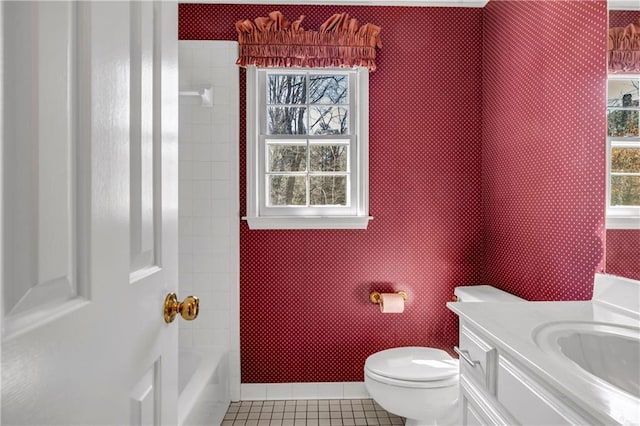 bathroom with tile patterned floors, toilet, a healthy amount of sunlight, and wallpapered walls