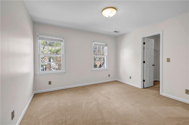 empty room featuring visible vents, baseboards, and carpet floors