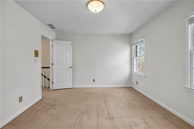 spare room featuring visible vents, carpet flooring, and baseboards