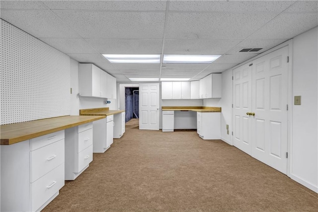 interior space featuring wallpapered walls, carpet, baseboards, and a paneled ceiling