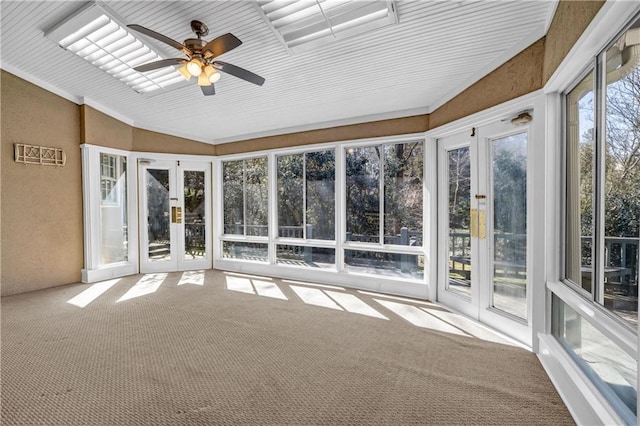 unfurnished sunroom with vaulted ceiling and a ceiling fan