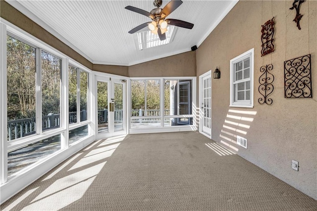 unfurnished sunroom with vaulted ceiling, a ceiling fan, and visible vents