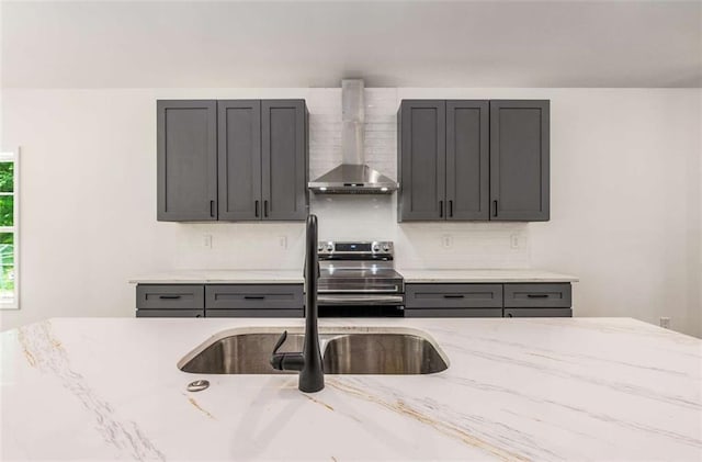 1317 Bernard St NW, Atlanta, GA 30314 - kitchen featuring wall chimney range hood, stainless steel range with electric stovetop, a sink, backsplash, and light stone counters