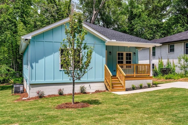 1317 Bernard St NW, Atlanta, GA 30314 - view of front of home featuring board and batten siding, covered porch, a front lawn, roof with shingles, and cooling unit