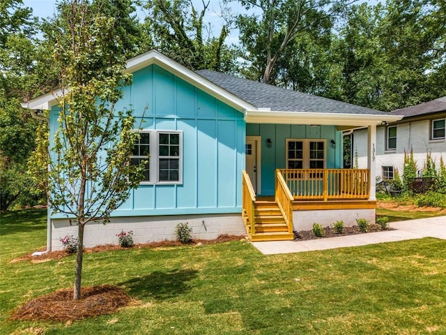1317 Bernard St NW, Atlanta, GA 30314 - view of front of house with board and batten siding, roof with shingles, a porch, and a front lawn