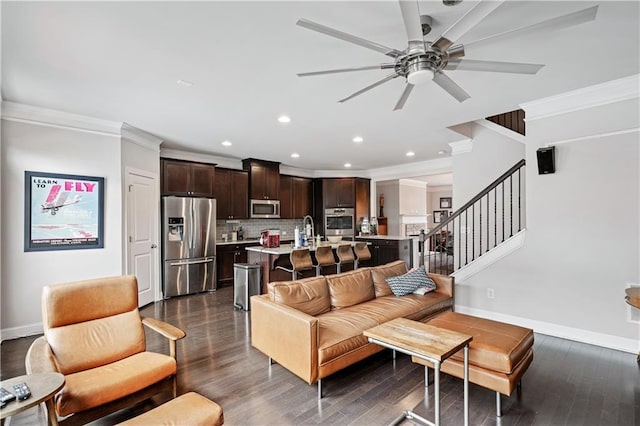 living room with ornamental molding, dark hardwood / wood-style flooring, sink, and ceiling fan