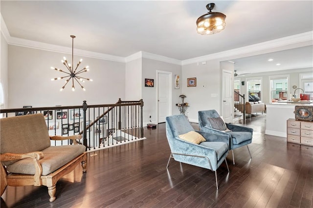 living area featuring crown molding, dark hardwood / wood-style flooring, and a chandelier