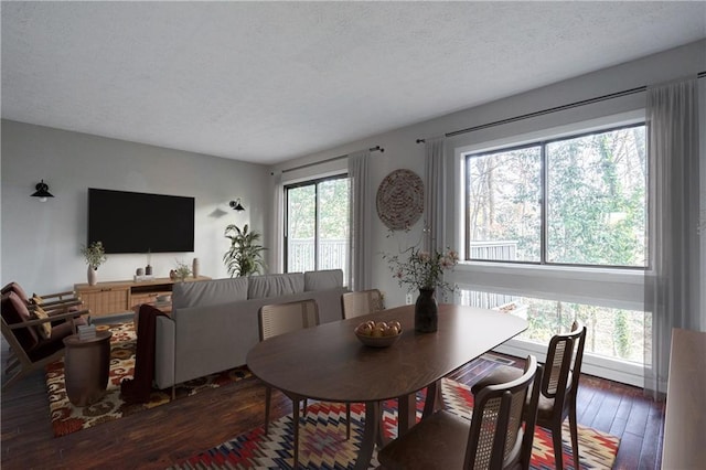 dining room with a textured ceiling and dark hardwood / wood-style floors