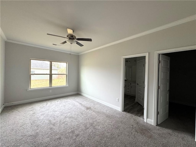 unfurnished bedroom featuring carpet flooring, baseboards, visible vents, and crown molding
