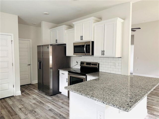 kitchen featuring white cabinets, appliances with stainless steel finishes, and light wood-style flooring