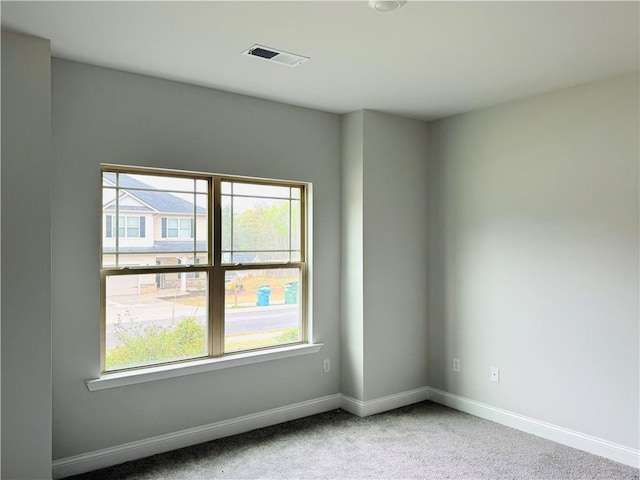 unfurnished room featuring baseboards, visible vents, a healthy amount of sunlight, and carpet